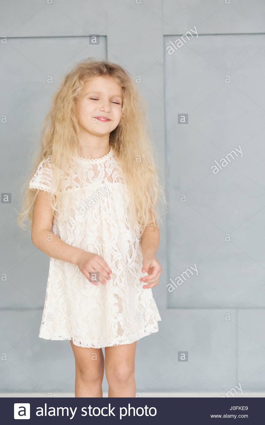 Little Cute Girl With Curly Blonde Hair In A Lace Dress On The