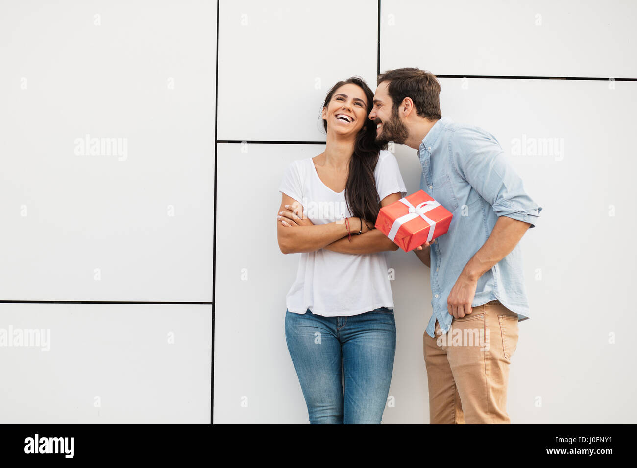 young man trying to reconcile his girlfriend offering her a gift Stock Photo