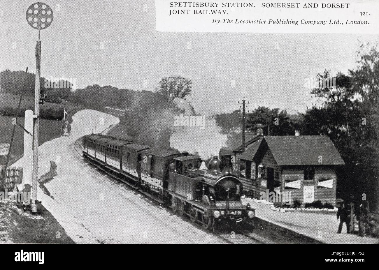 Spettisbury station: platform, signalling and station buildings with train under steam Stock Photo