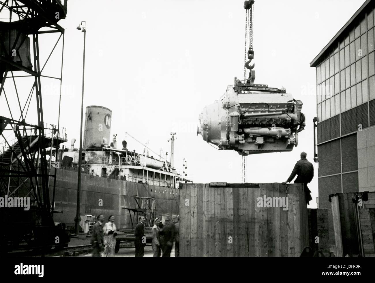 Deltic marine compound engine hanging suspended from a lifting hook Stock Photo