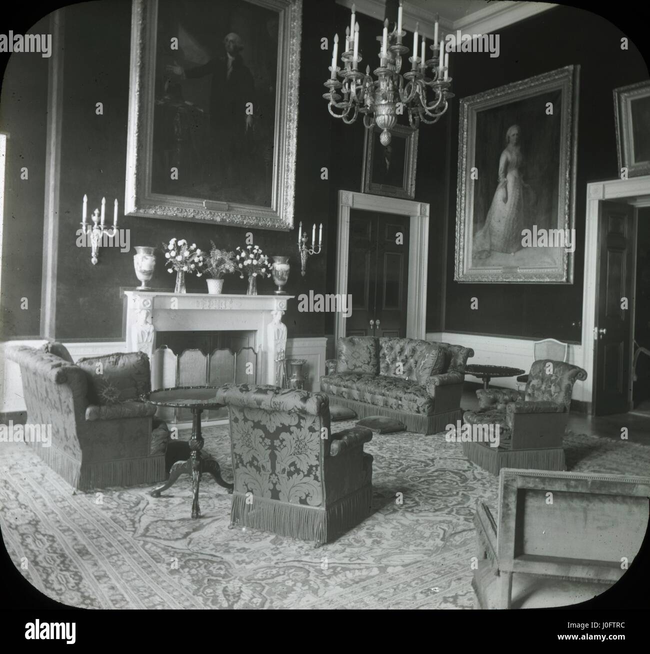 Richly decorated sitting room with portraits on the walls, with couch