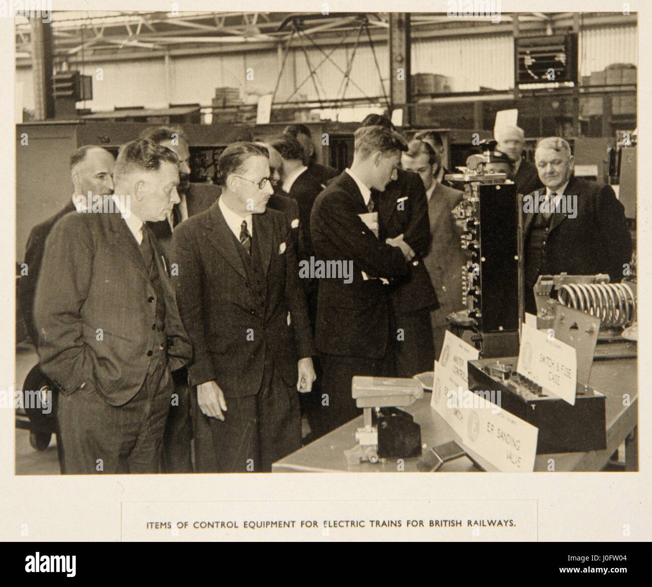 Men look at an exhibition of control equipment for electric trains for British Railways Stock Photo