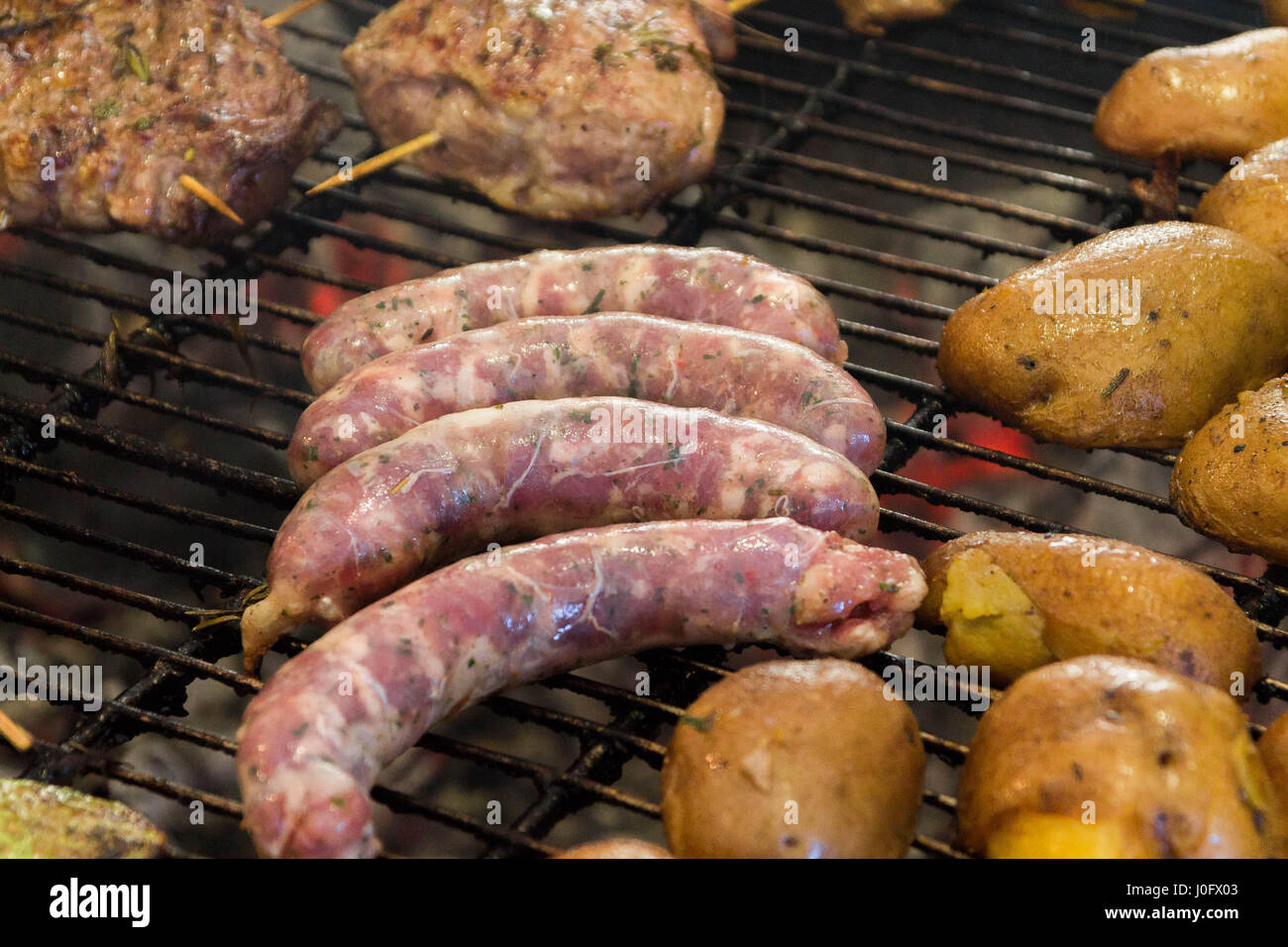 Cooking sausages. Frying sausages. Sausages on the grill Stock Photo