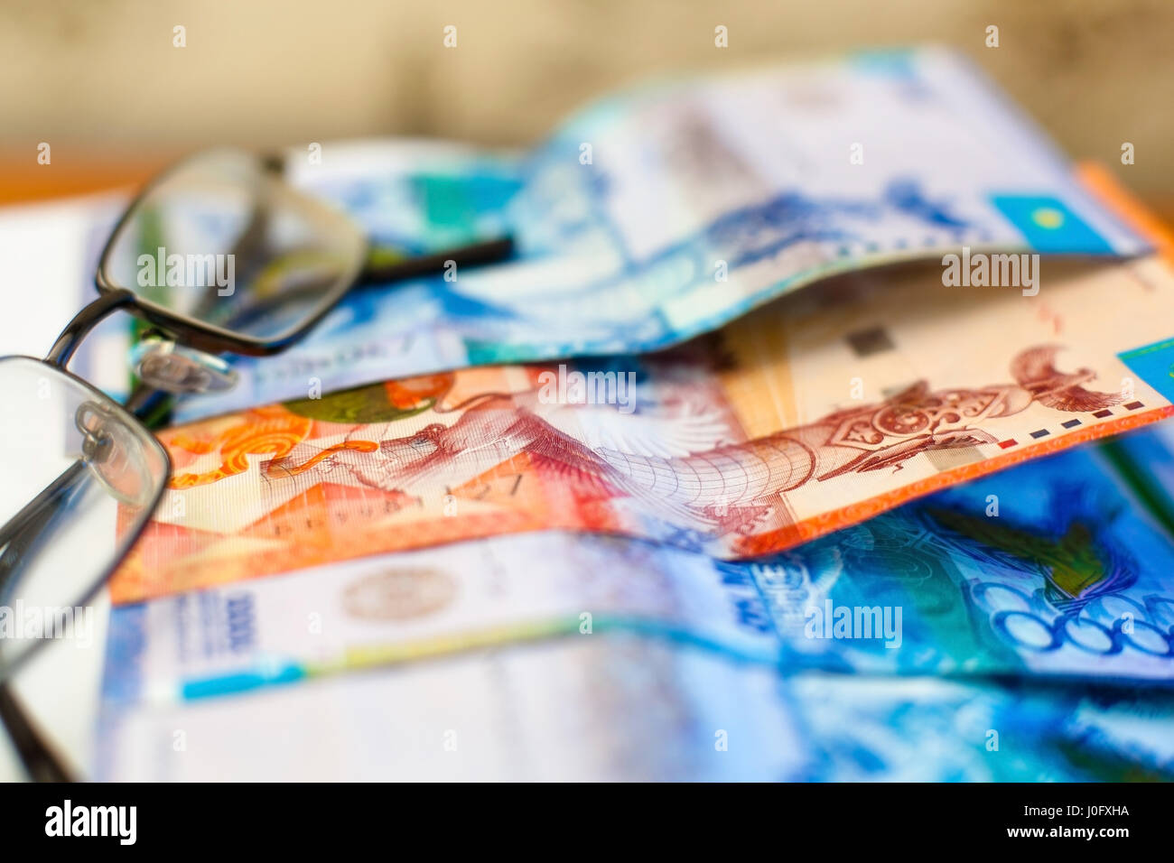 Kazakhstan money and glasses. Paper banknotes of tenge. Stock Photo