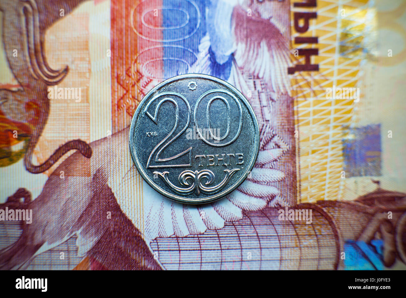 The coin is twenty tenge against the background of paper Kazakhstan money. Stock Photo