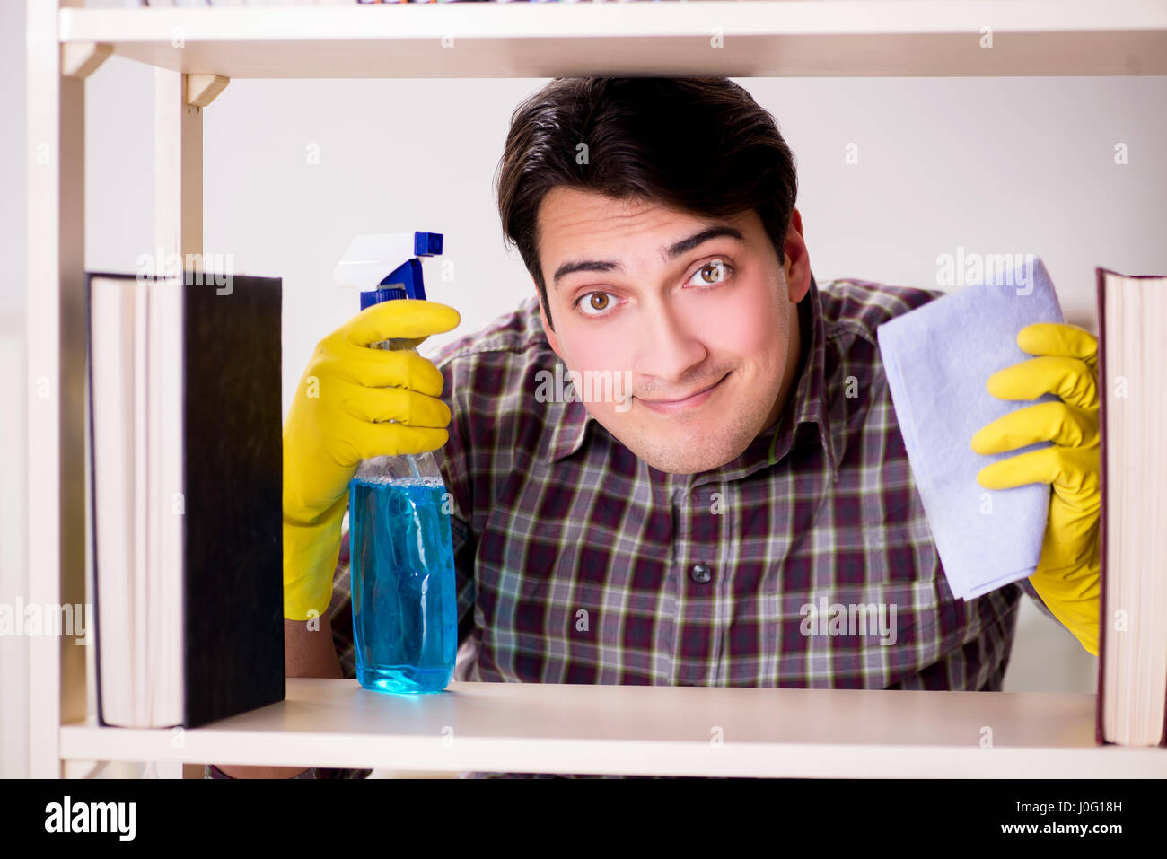 Man cleaning dust from bookshelf Stock Photo Alamy