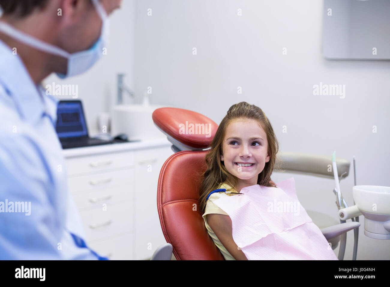 Smiling dentist talking to young patient in dental clinic Stock Photo ...