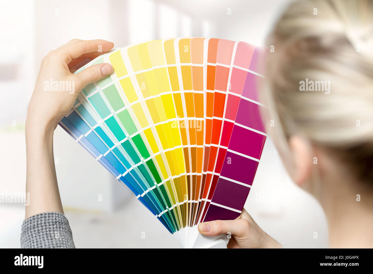 woman selecting home interior paint color from swatch catalog Stock Photo