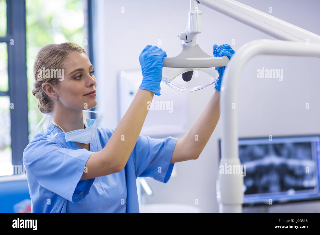 Female nurse adjusting dental light in clinic Stock Photo Alamy