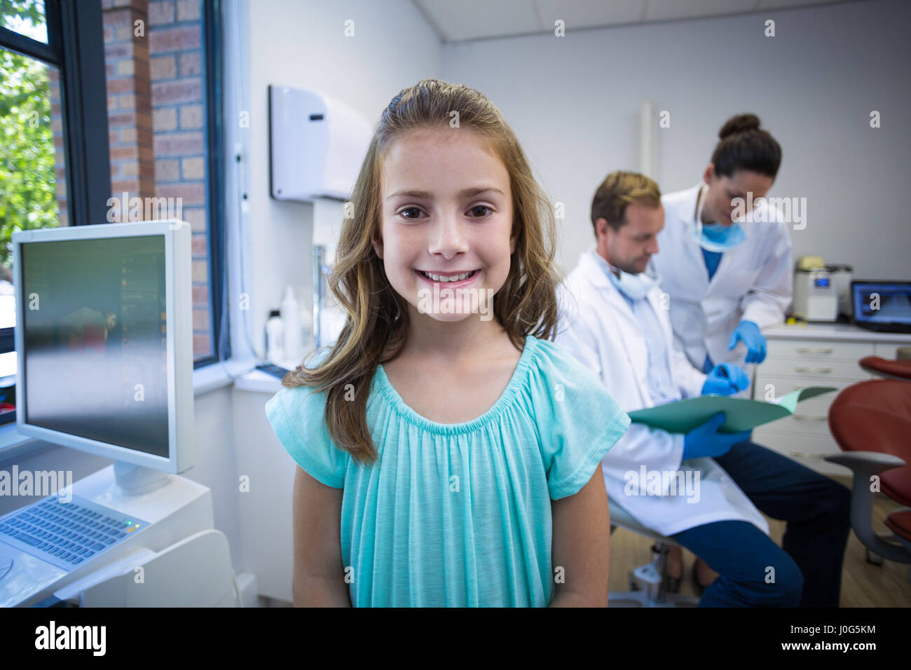 Portrait of smiling young patient standing in dental clinic Stock Photo