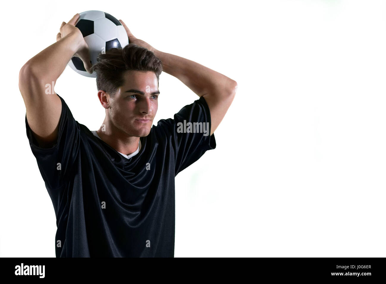 Football player about to throw the football against white background