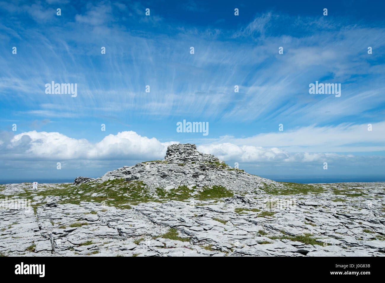 Limestone pavement and cairn at the summit of Dobhach Bhrainin, Gleninagh Mountain, The Burren, County Clare, Ireland Stock Photo