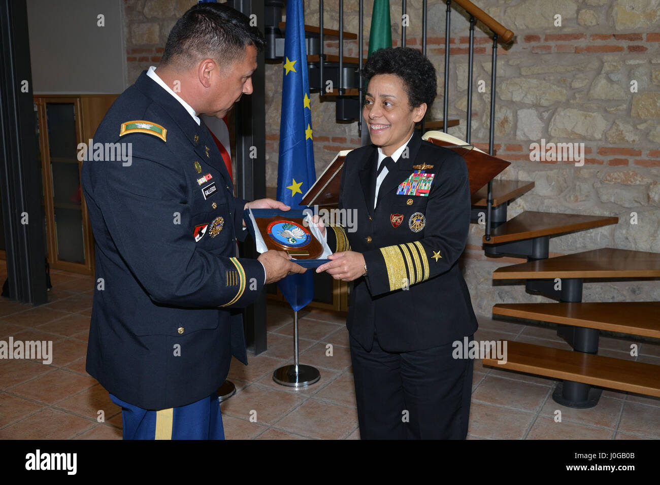 U.S. Army Col. Darius S. Gallegos, CoESPU deputy director (left), presents Carabinieri CoESPU crest to Admiral Michelle Howard, NATO JFC-Naples Commander, during the visit at the Center of Excellence for Stability Police Units (CoESPU) Vicenza, April 10, 2017. (U.S. Army Photo by Visual Information Specialist Paolo Bovo/released) Stock Photo