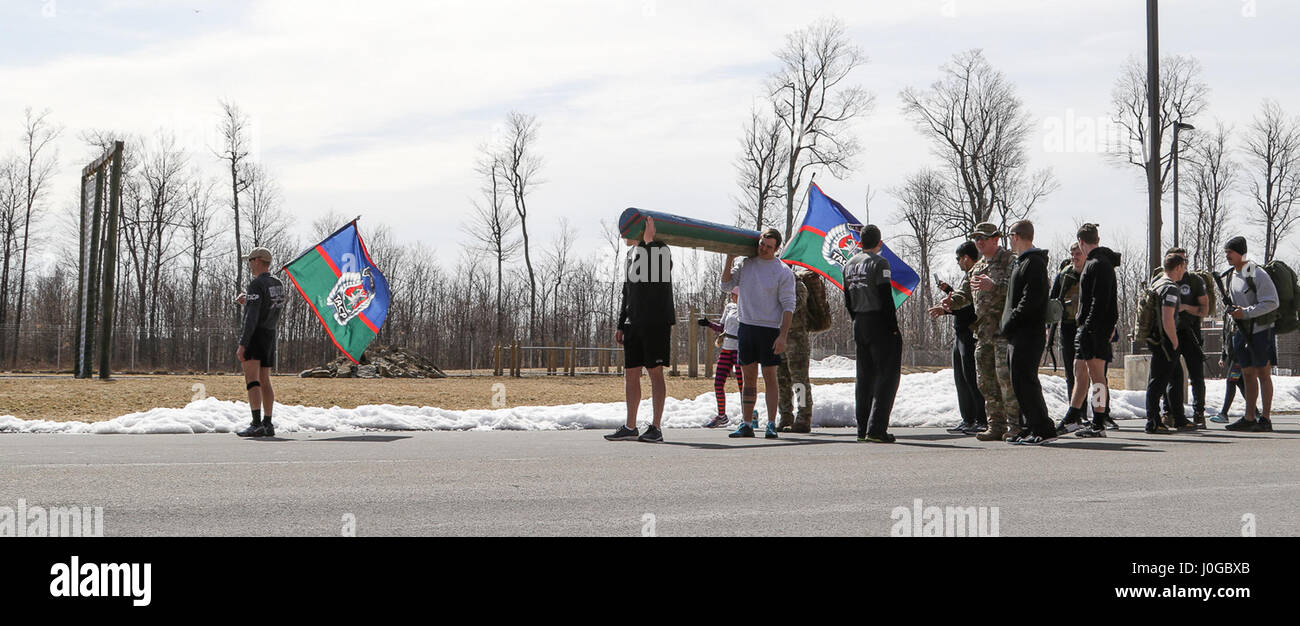 The 20th Air Support Operations Squadron and other TACP community volunteers stand ready at the starting line to the half-mile designated loop around their compound on Fort Drum March 30 moments before the noon start time for the 24 hour carrying of the TACP colors memorial event. Participants can choose to run, walk or ruck march during the event as long as the colors keep moving. Stock Photo