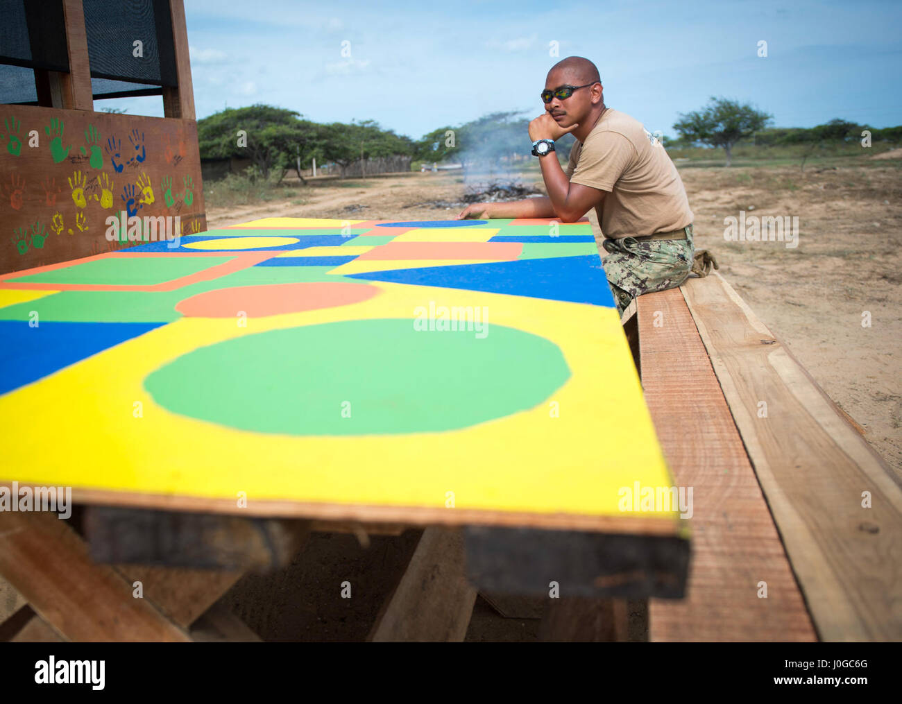 170330-N-YL073-002 MAYAPO, Colombia (March 30, 2017) - Construction Electrician 2nd Class JanRainier San Juan, a native of Fountain, Colo., assigned to Construction Battalion Maintenance Unit (CBMU) 202, Norfolk, Va., sits at a table constructed for a Wayuu tribe in Mayapo, Colombia, during Continuing Promise 2017 (CP-17). CP-17 is a U.S. Southern Command-sponsored and U.S. Naval Forces Southern Command/U.S. 4th Fleet-conducted deployment to conduct civil-military operations including humanitarian assistance, training engagements, medical, dental, and veterinary support in an effort to show U. Stock Photo