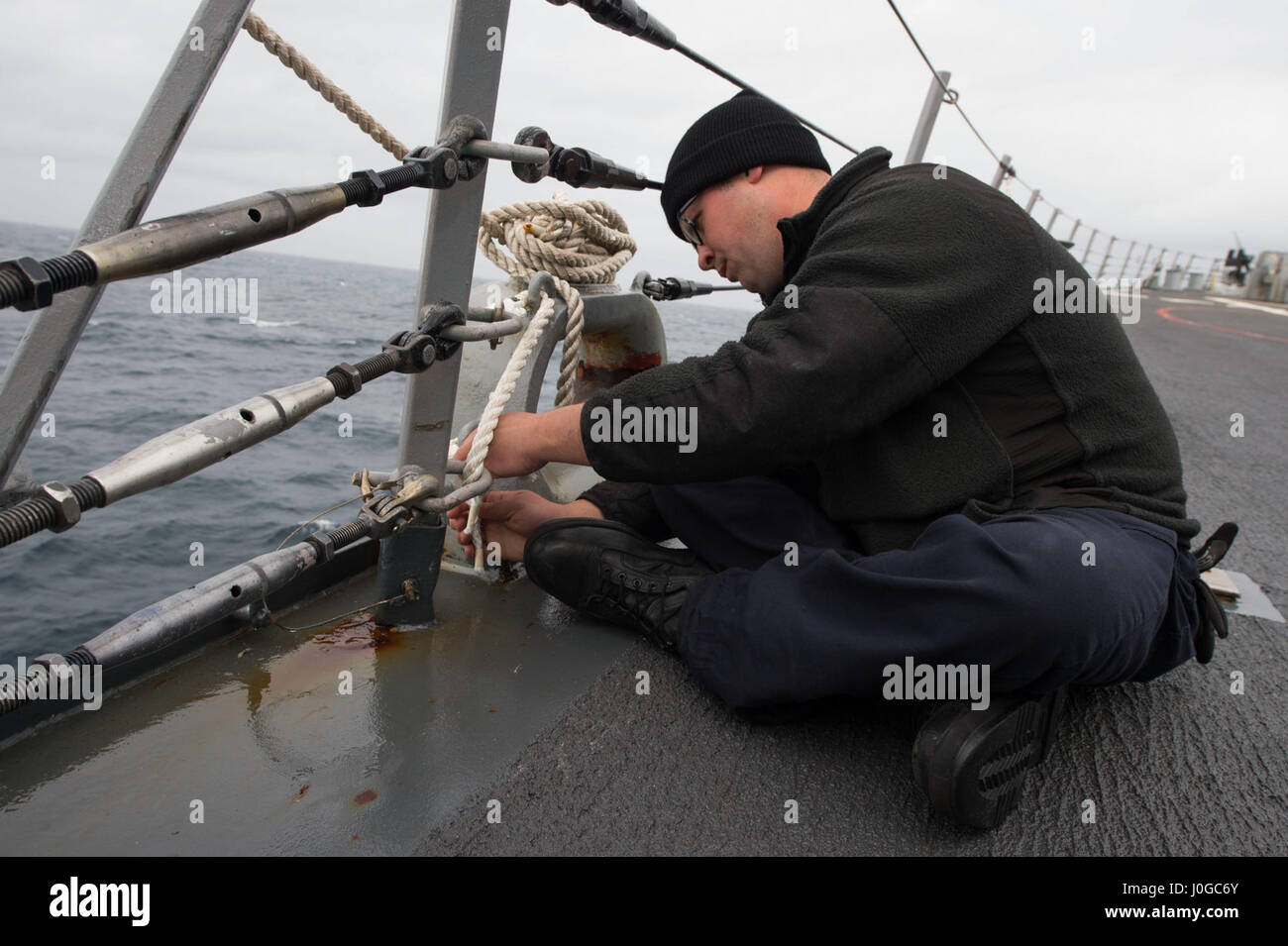 170330-N-ZE250-009   ATLANTIC OCEAN - (March 30, 2017) - Seaman Jason Reese replaces life lines on the forecastle of USS Carney (DDG 64) during exercise Joint Warrior 17-1 March 30, 2017. Carney, an Arleigh Burke-class guided-missile destroyer, forward-deployed to Rota, Spain, is conducting its third patrol in the U.S. 6th Fleet area of operations in support of U.S. national security interests in Europe. (U.S. Navy photo by Mass Communication Specialist 3rd Class Weston Jones/Released) Stock Photo