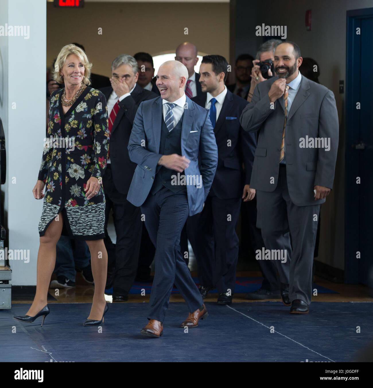 U.S. Secretary of Education Betsy DeVos, left, walks with rapper Pitbull at a charter school he supports in Little Havana during a visit to SLAM April 6, 2017 in Miami, Florida. The controversial education secretary made several stops including her first visit to a public university, a private christian school and the charter school. Stock Photo