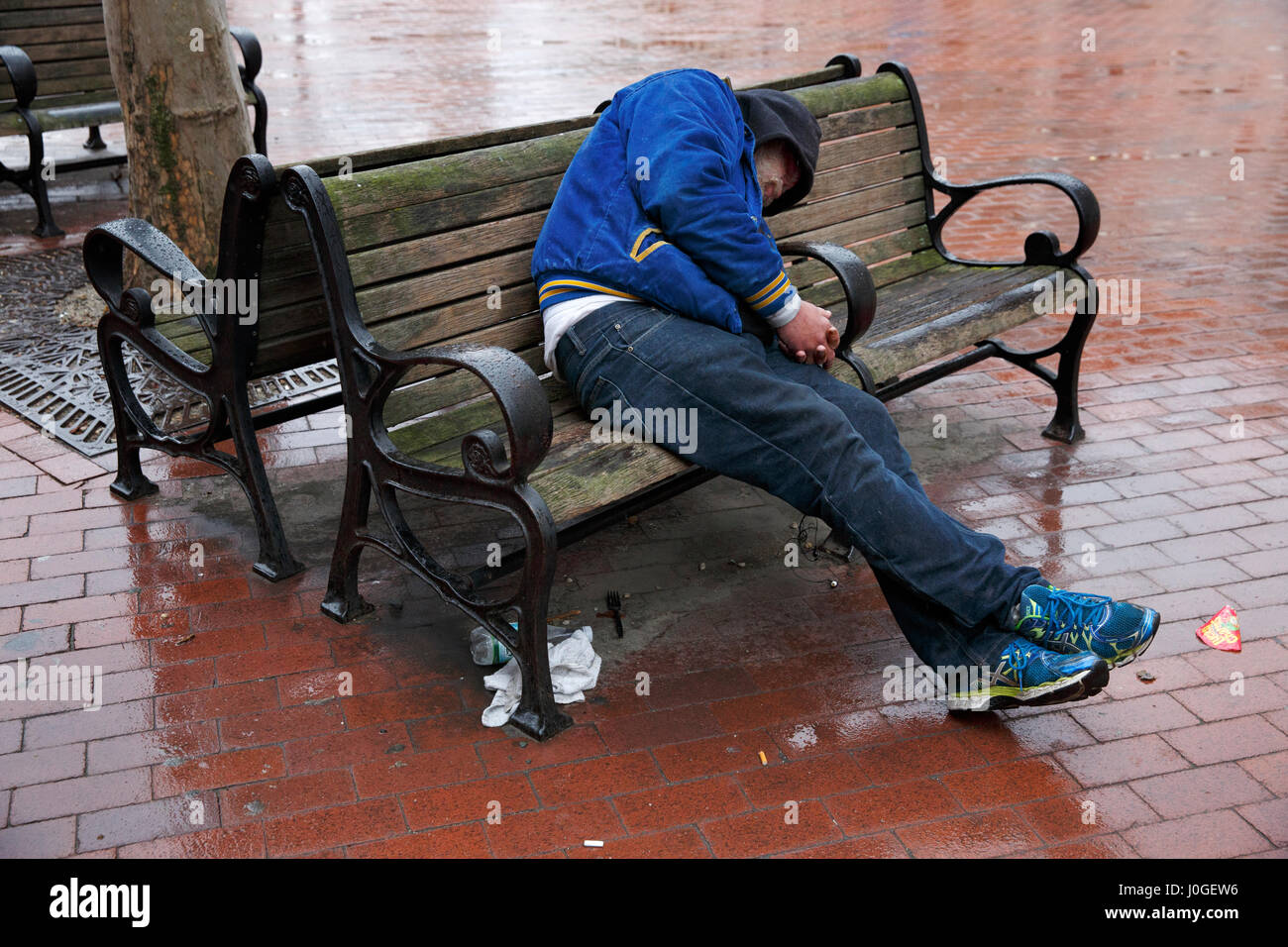 Homeless man passed out on a park bench, Boston, Massachusetts Stock Photo