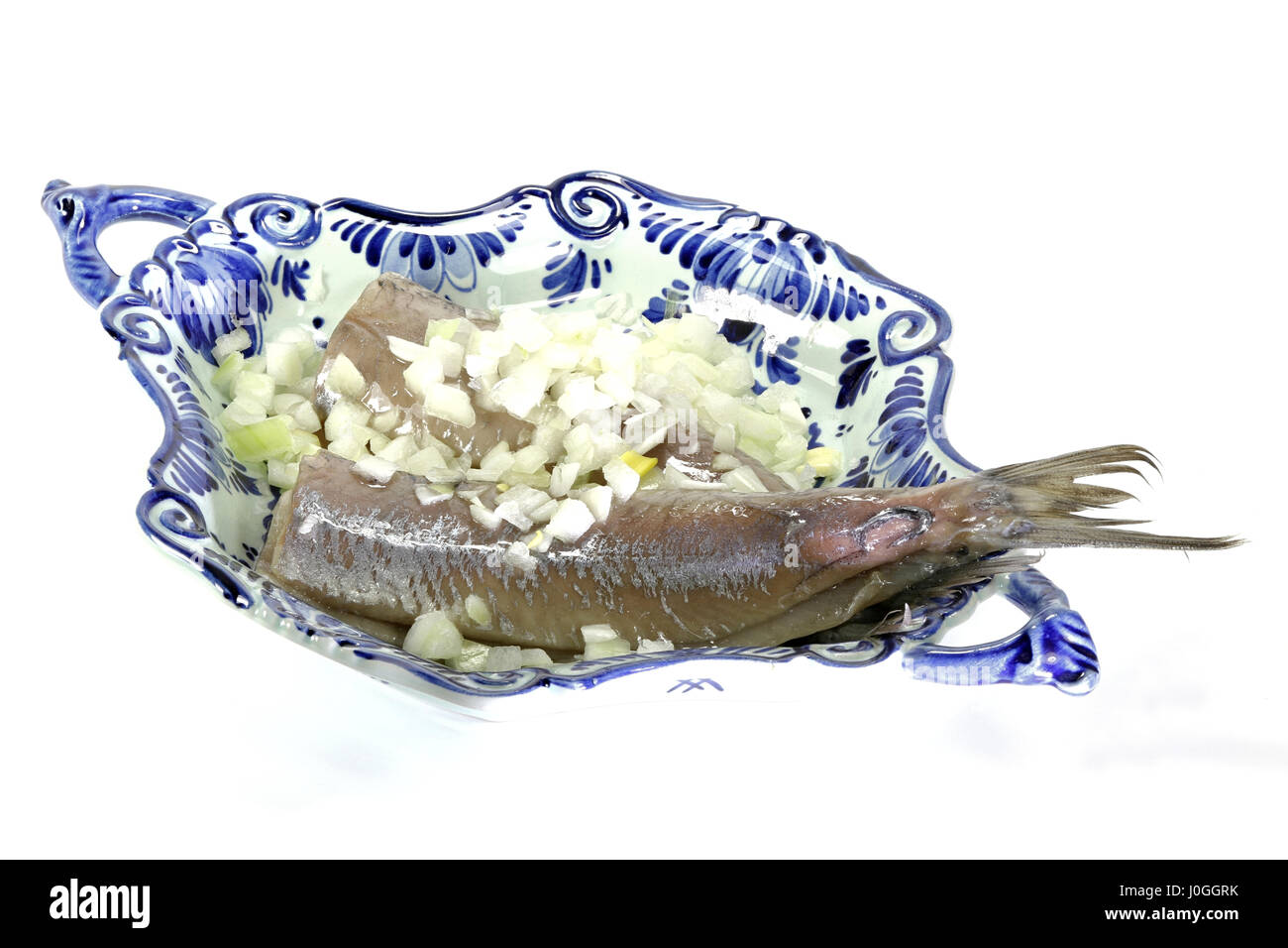 soused herring in delftware bowl isolated on white background Stock Photo
