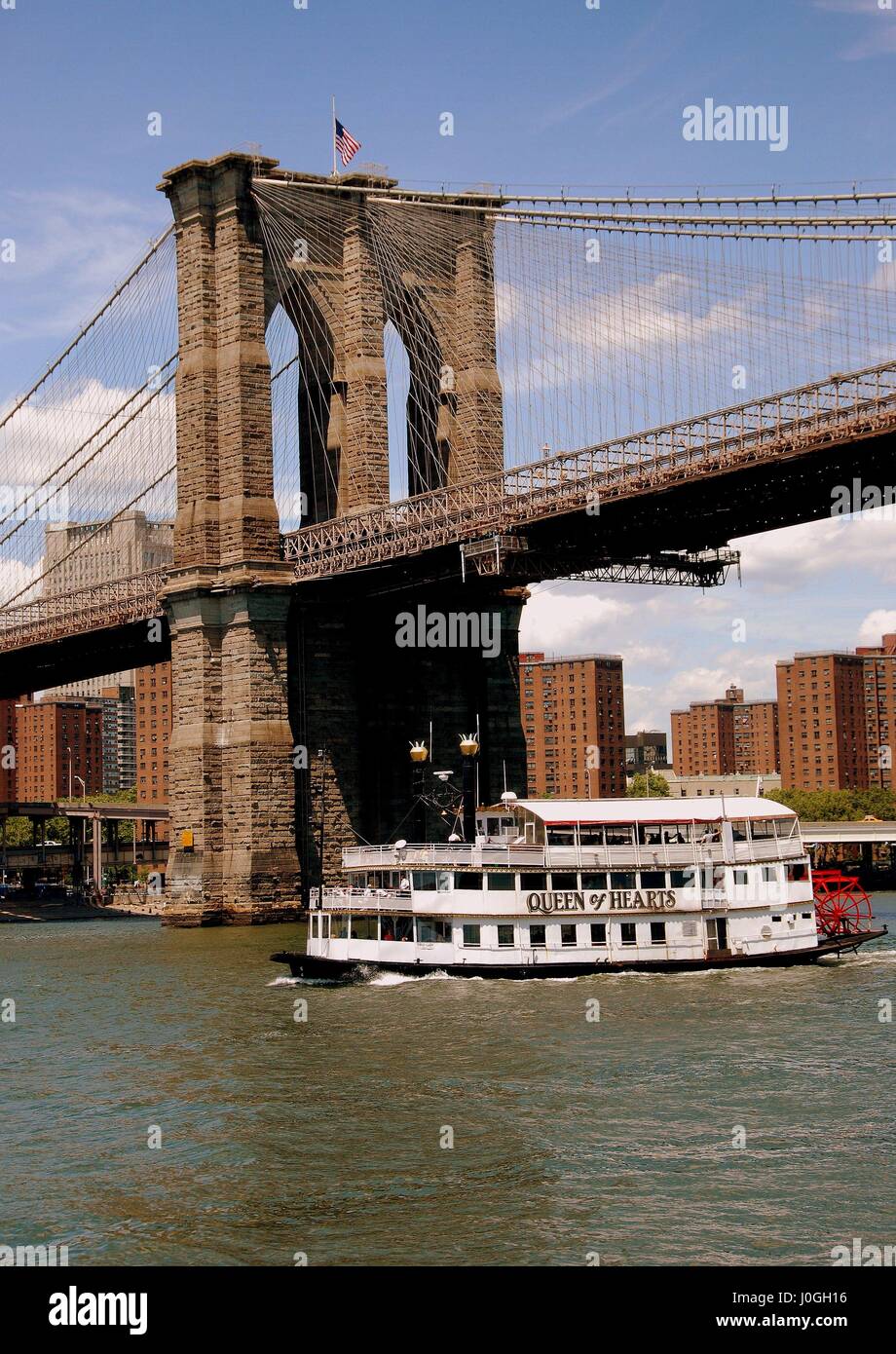 New York City - July 19, 2009:  Brooklyn Bridge west tower and Queen of Hearts touring boat on the East River Stock Photo