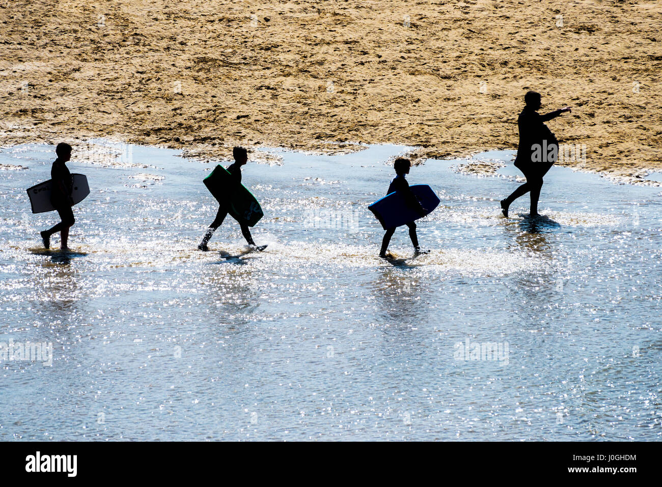 Seaside Crantock Beach Father Children Silhouettes Silhouetted Bodyboards Walking Sea Sand Holidaymakers People Figures Leading Shore Stock Photo