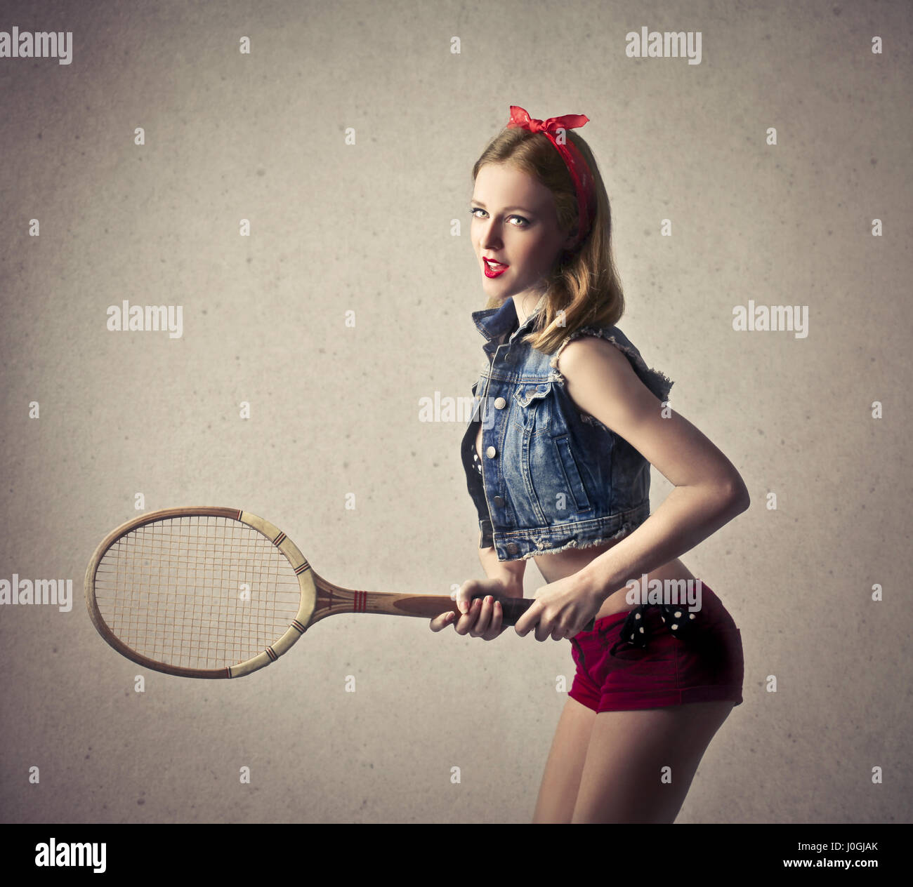 Blond pin-up woman with tennis racket Stock Photo - Alamy