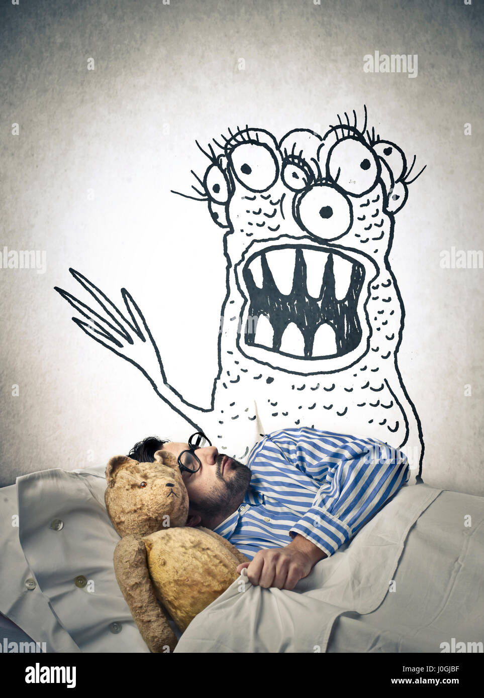 Sleeping man being afraid of drawn monster Stock Photo