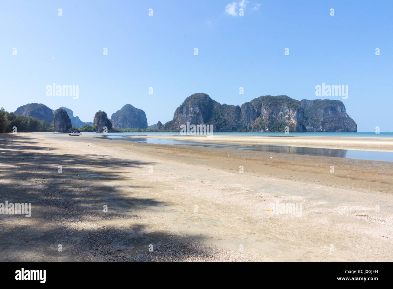 Boat on Rajamangala beach with limestone cliffs in the background,Trang province, Thailand Stock Photo
