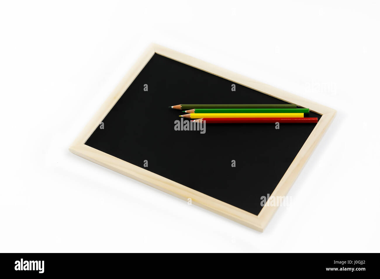 Color pencil on black board isolated on white background Stock Photo
