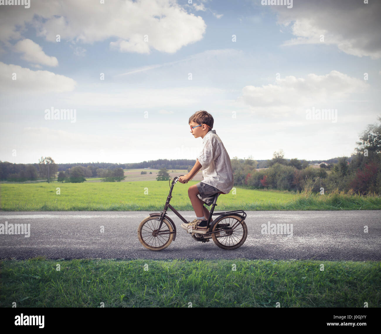 Little boy riding bike on countryside Stock Photo
