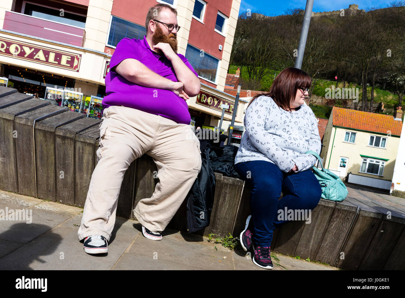 Obesity in UK fat people sat resting inbetween meals fat middle fat belly fat bellies overweight people unhealthy lifestyle unhealthy weight fatties Stock Photo