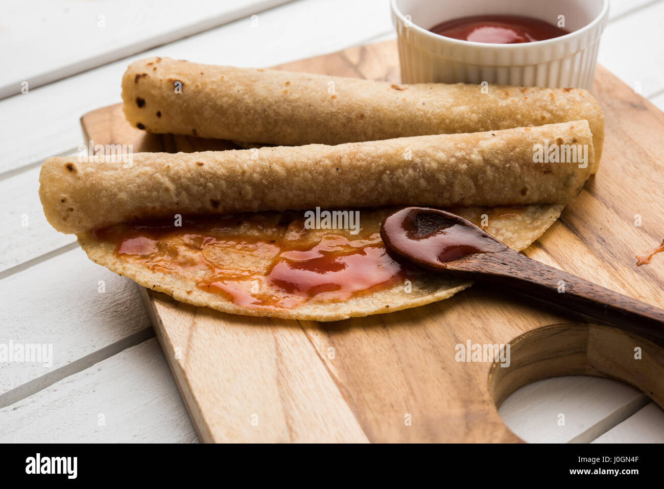 indian bread or chapati or paratha rolled with fruit jam, typical ...
