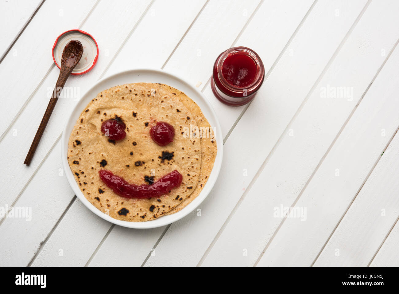 ketchup or fruit jelly/jam smile emoticon over indian bread / chapati