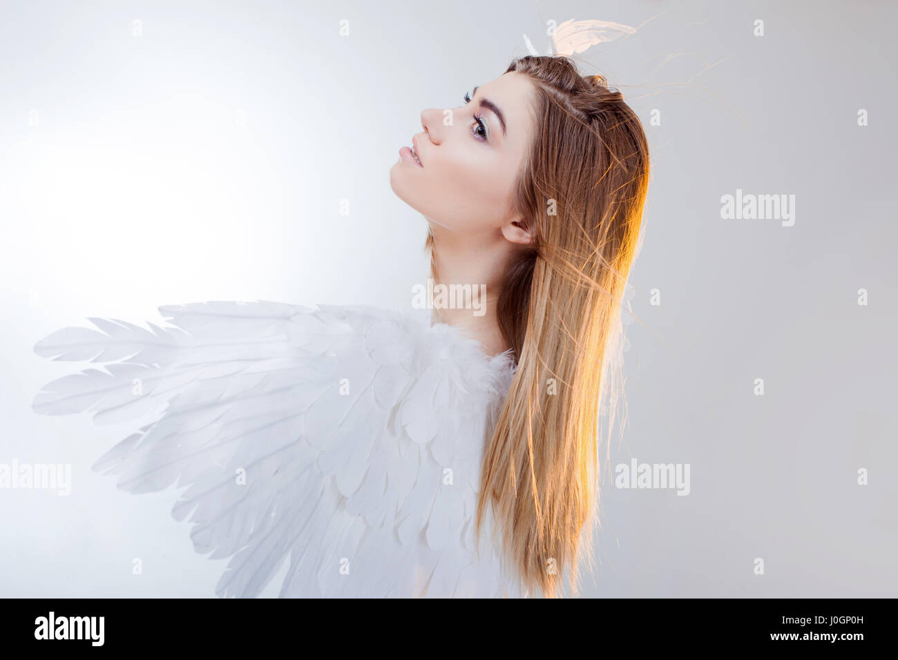 Young and wonderful blonde girl in the image of an angel with white ...