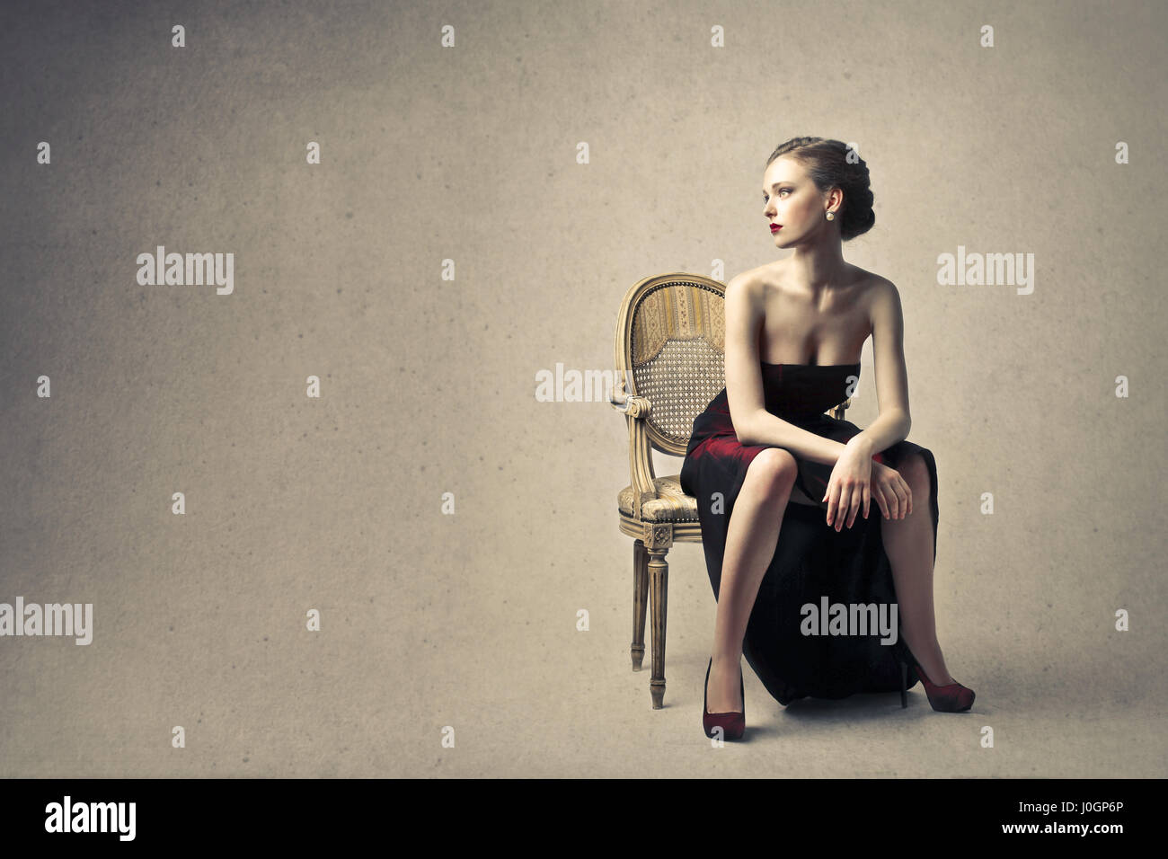 Elegant woman sitting on chair Stock Photo