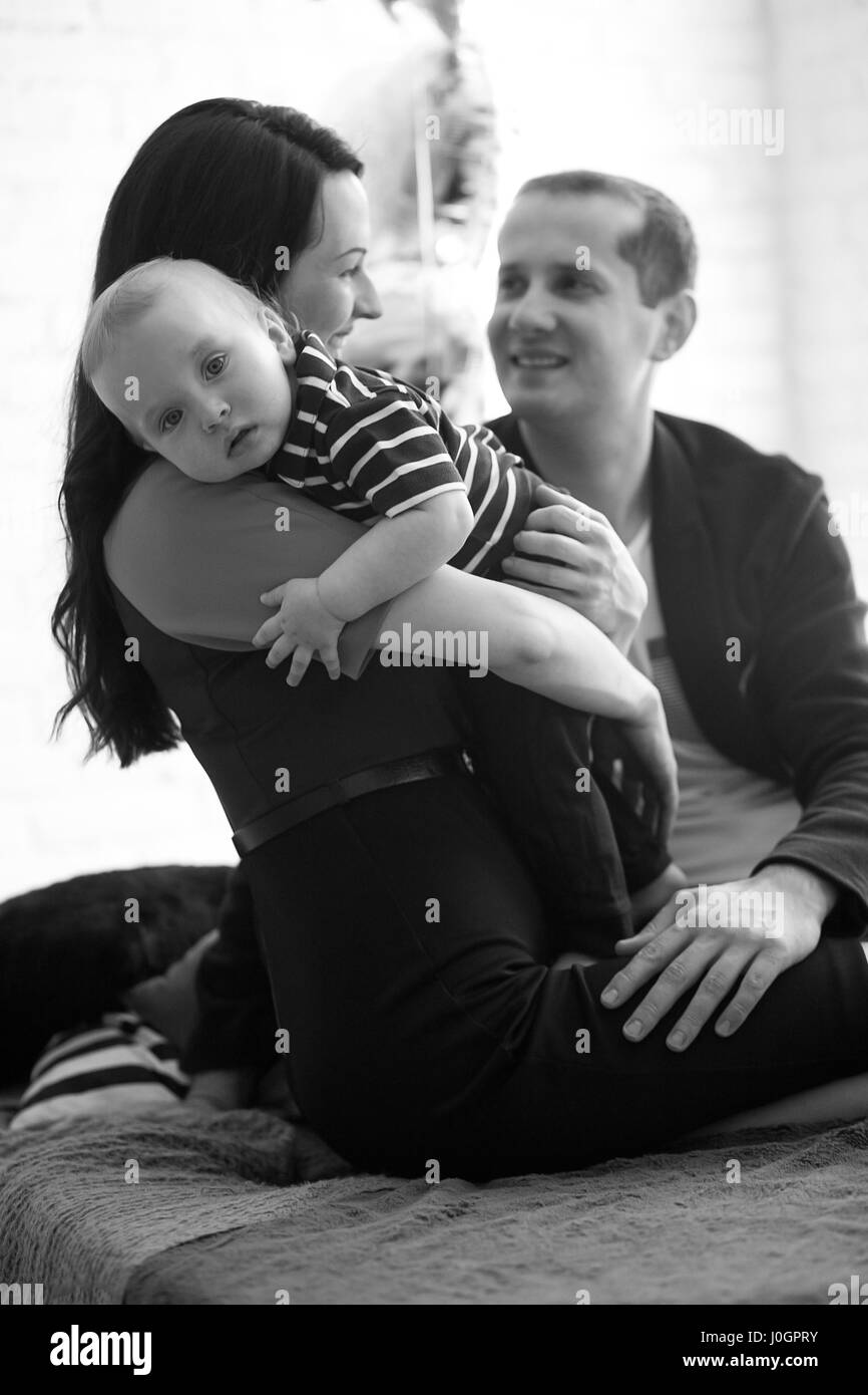Baby with parents at mother's hands. Black and white image. Stock Photo