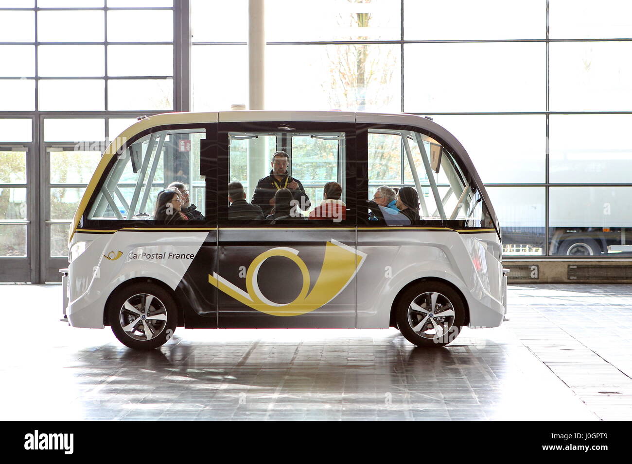Hanover, Germany. 21th March, 2017. self-driving electric minibus by PostAuto Switzerland (here its french subsidiary CarPostal France) invides fair visitors for a test drive with this 'SmartShuttle' through fair hall 13. This autonomous bus (Model name: Arma) is manufactured by Navya SAS (France), is considered first autonomous series vehicle for local trafiic, in usage since 2016 (e.g. Switzerland, France), max. 15 persons, max. speed 45 km/h. CeBIT 2017, ICT trade fair, lead theme 'd!conomy - no limits'. Photocredit: Christian Lademann Stock Photo