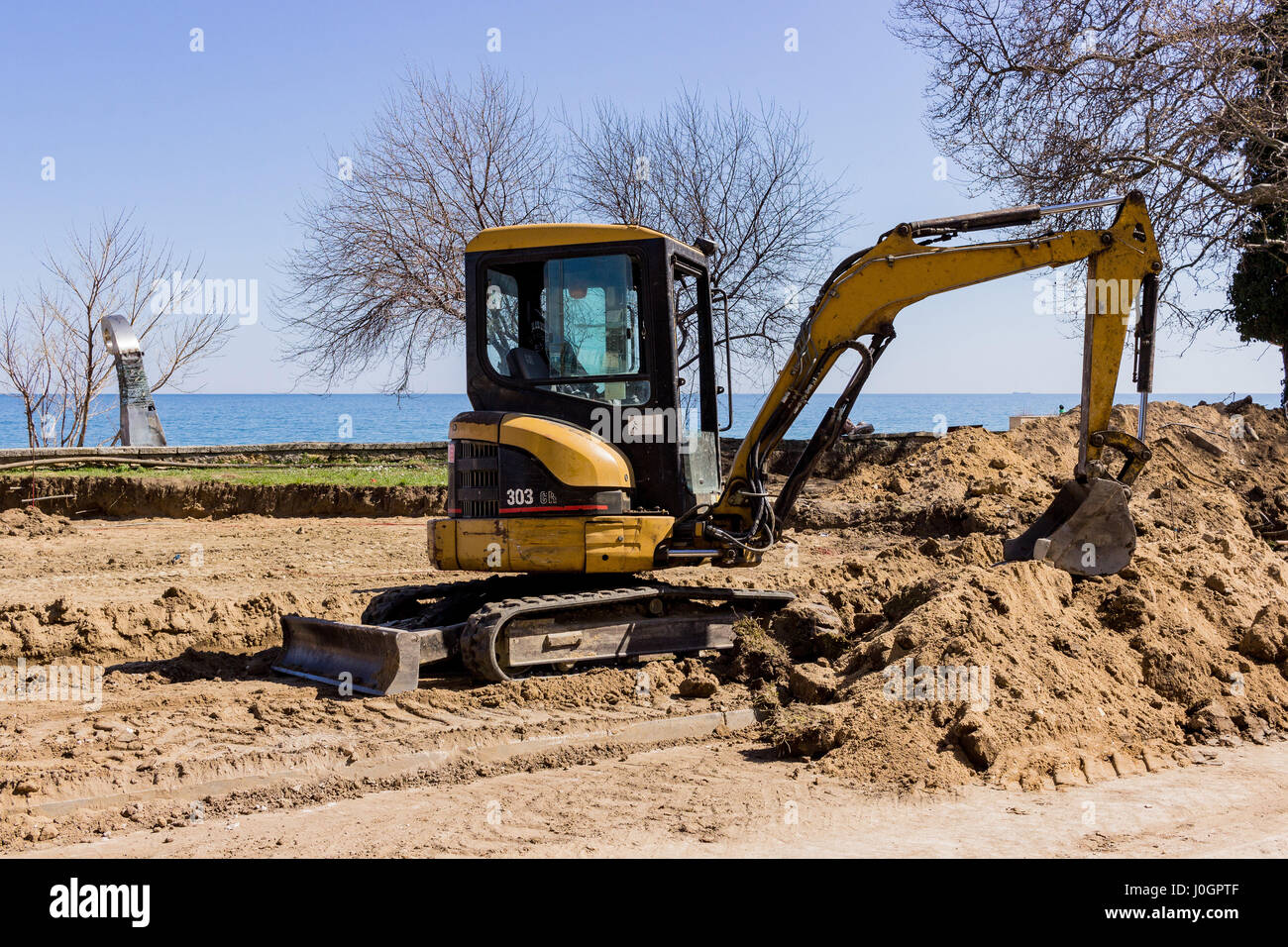 A small excavator is digging sand for a new road Stock Photo Alamy