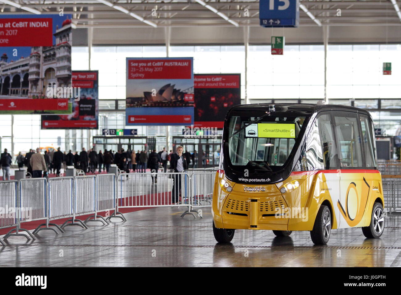 Hanover, Germany. 21th March, 2017. self-driving electric minibus by PostAuto Switzerland invides fair visitors for a test drive with this 'SmartShuttle' through fair hall 13. This autonomous bus (Model name: Arma) is manufactured by Navya SAS (France), is considered first autonomous series vehicle for local trafiic, in usage since 2016 (e.g. Switzerland, France), max. 15 persons, max. speed 45 km/h. CeBIT 2017, ICT trade fair, lead theme 'd!conomy - no limits'. Photocredit: Christian Lademann Stock Photo