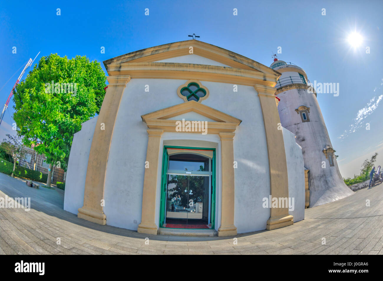 Fish-eye view of facade Guia Lighthouse, Fortress and Chapel in Historic Centre of Macau, China. Sunny day, blue sky. Front view. Stock Photo