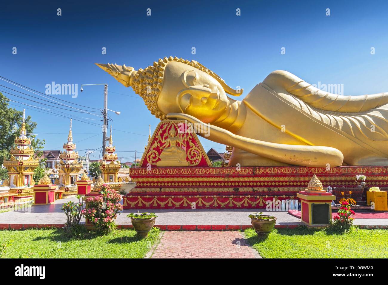 Giant gold reclining sleeping Buddha statue near Wat That Luang Temple, Vientiane, Laos Stock Photo