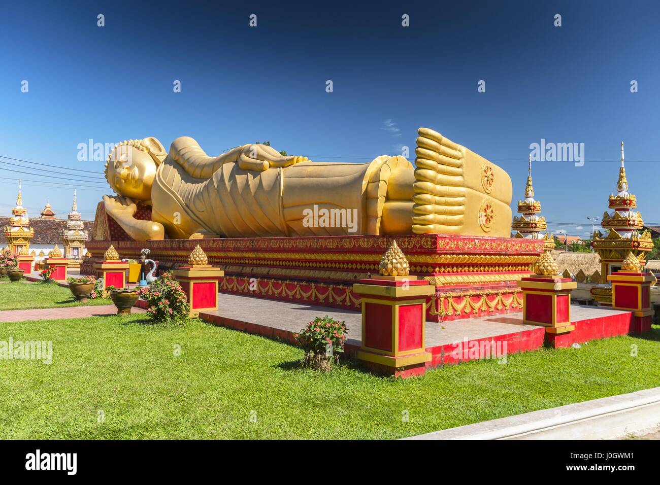 Giant gold reclining sleeping Buddha statue near Wat That Luang Temple, Vientiane, Laos Stock Photo