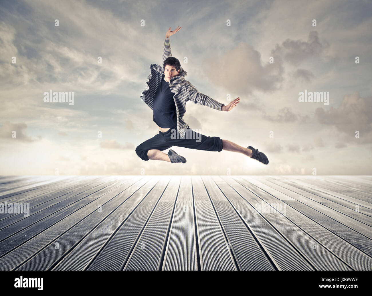 Dancer man jumping on pier Stock Photo