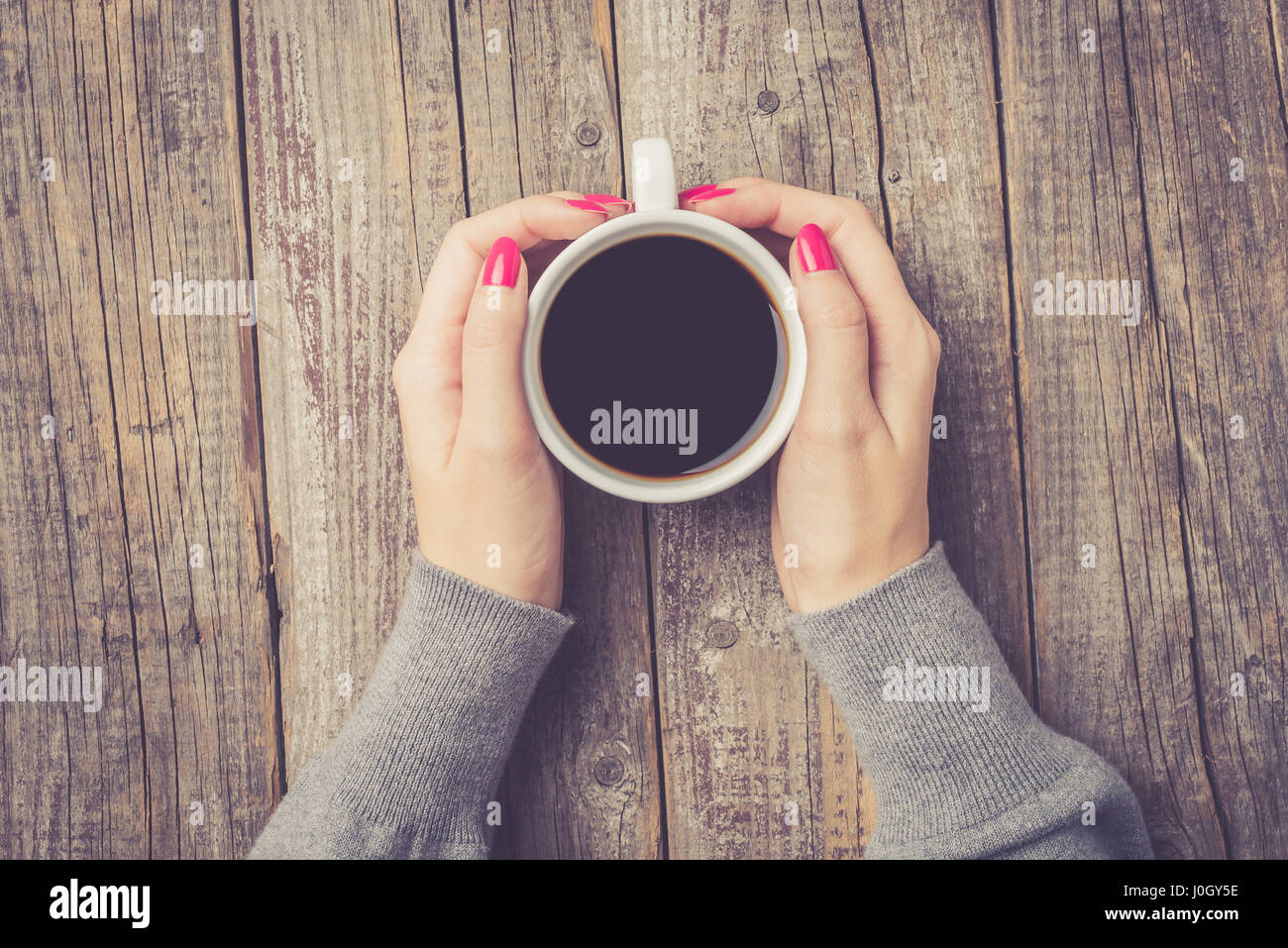 Female hands holding coffee cup. Top view Stock Photo - Alamy