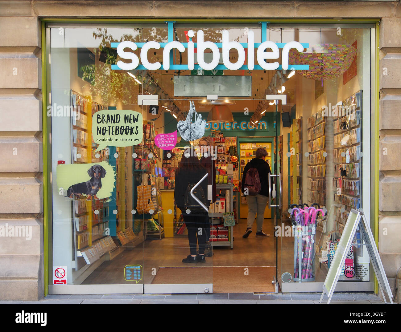 Entrance and window display of Manchester city centre stationary shop Scribbler, showing both the exterior and interior of the store, with customers. Stock Photo