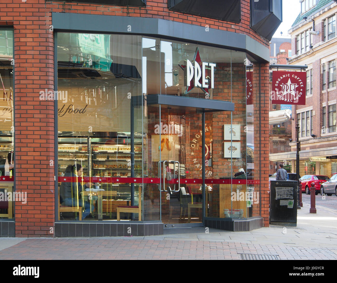 Exterior shot of the of the coffee shop cafe Pret a Manger, in the city centre of Manchester, showing the interior displays + customers drinking. Stock Photo
