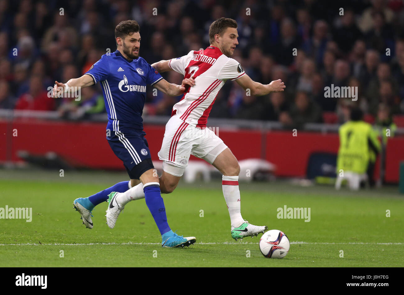 Amsterdam, Netherlands. 13th Apr, 2017. Schalke's Daniel Caligiuri and Ajax's Joel Veltman (R) vie for the ball during the first leg of the Europa League quarter final match between AFC Ajax and FC Schalke 04 in the Amsterdam Arena in Amsterdam, Netherlands, 13 April 2017. Photo: Ina Fassbender/dpa/Alamy Live News Stock Photo
