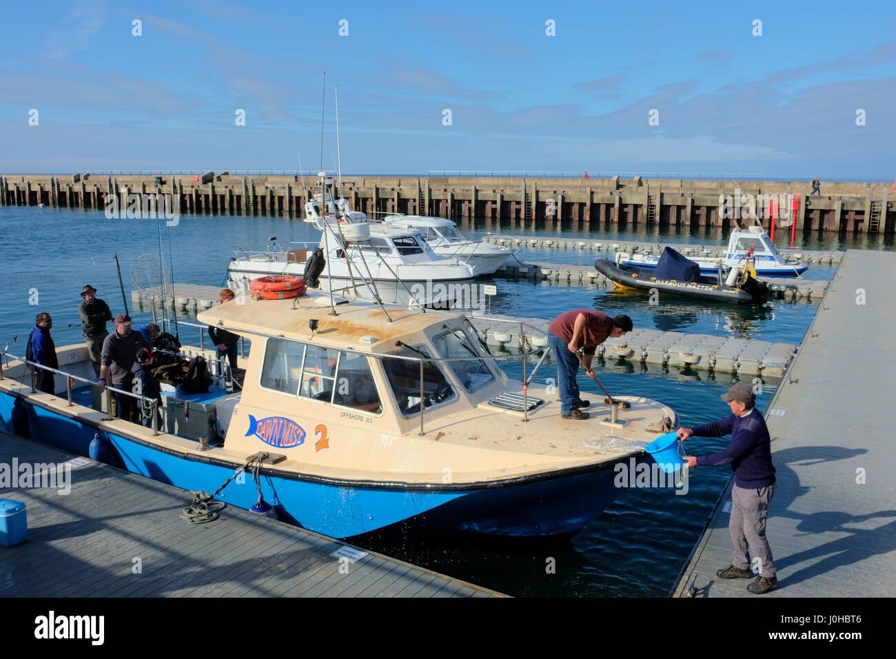 West Bay, Dorset, UK. 14th Apr, 2017. A fishing boat is given a final wash as anglers wait fir the start of their fishing trip from a sunny West Bay harbour on the Dorset coast. Credit: Tom Corban/Alamy Live News Stock Photo