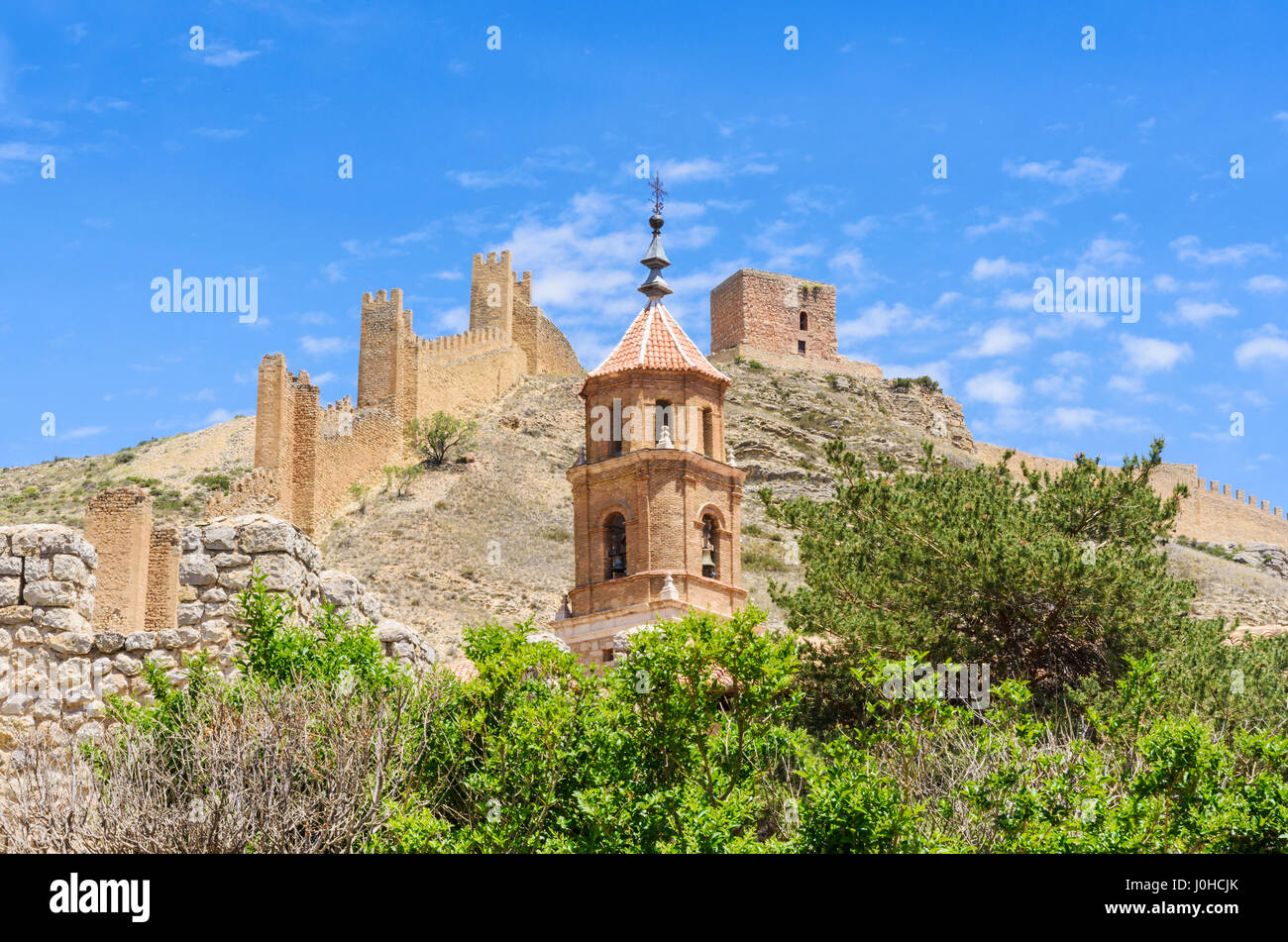 Albarracin northern walls and the Torre del Andador overlooking the Parish church of Santa Maria and Santiago bell tower in the Medieval walled town Stock Photo