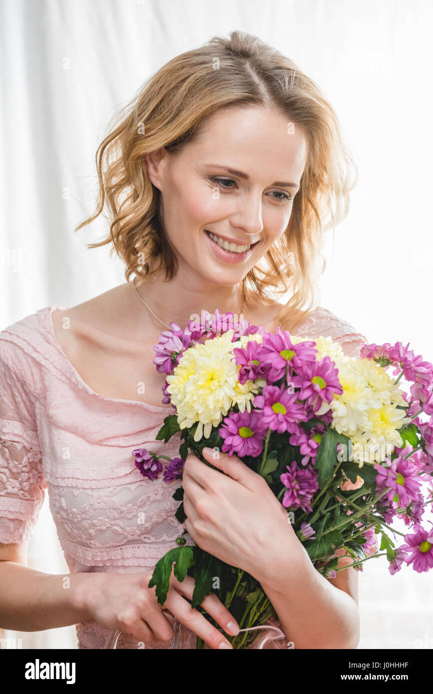 Young beautiful woman holding bouquet of fresh flowers and smiling ...